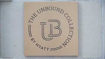 Un letrero con el texto 'THE UNBOUND COLLECTION BY HYATT' sobre un fondo color beige.
