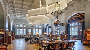Un vestíbulo amplio con techos altos, candelabros ornamentales y una extensa zona de bar.