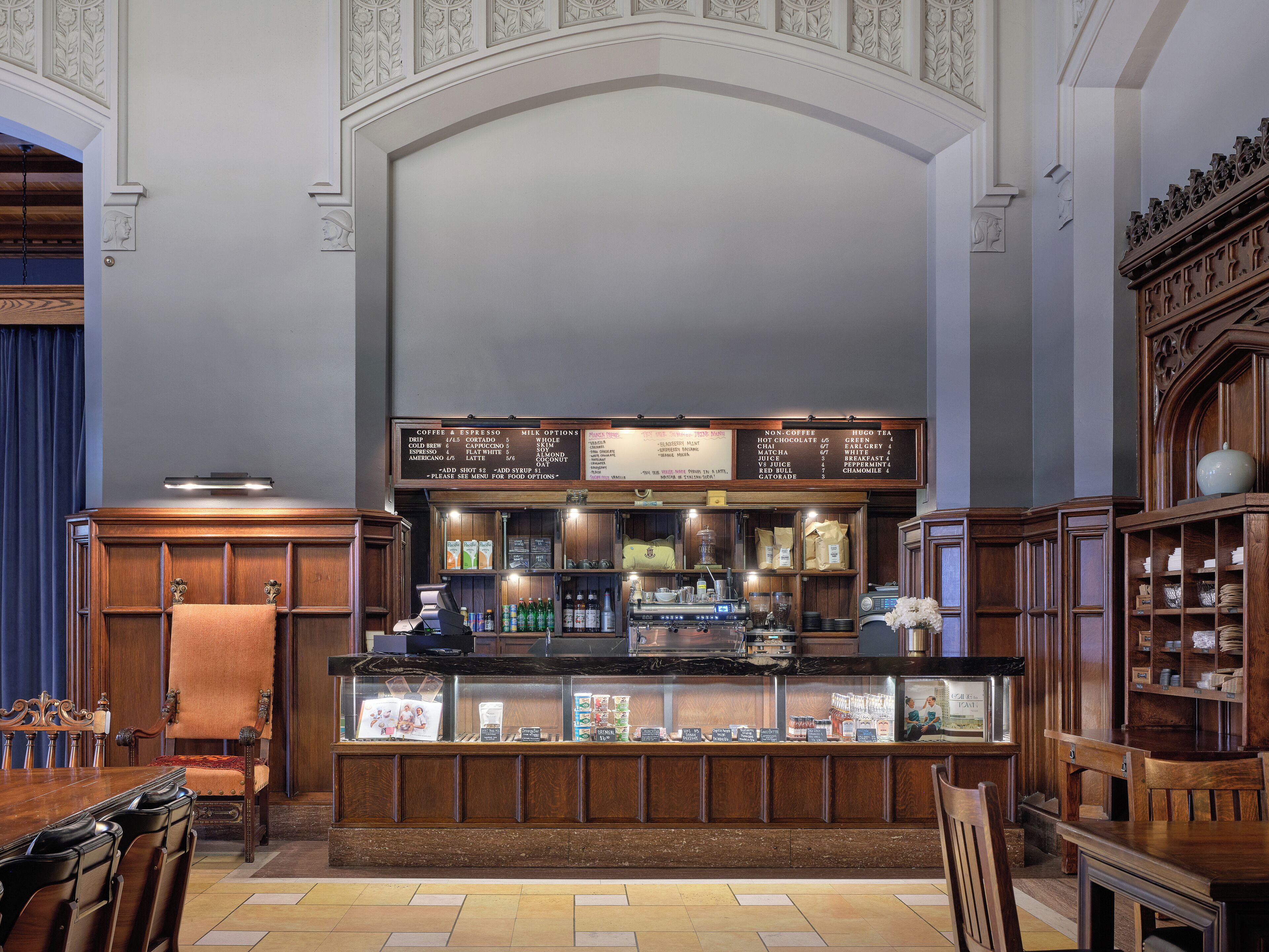 A bar area with a menu board, wooden furnishings, and a seating arrangement.