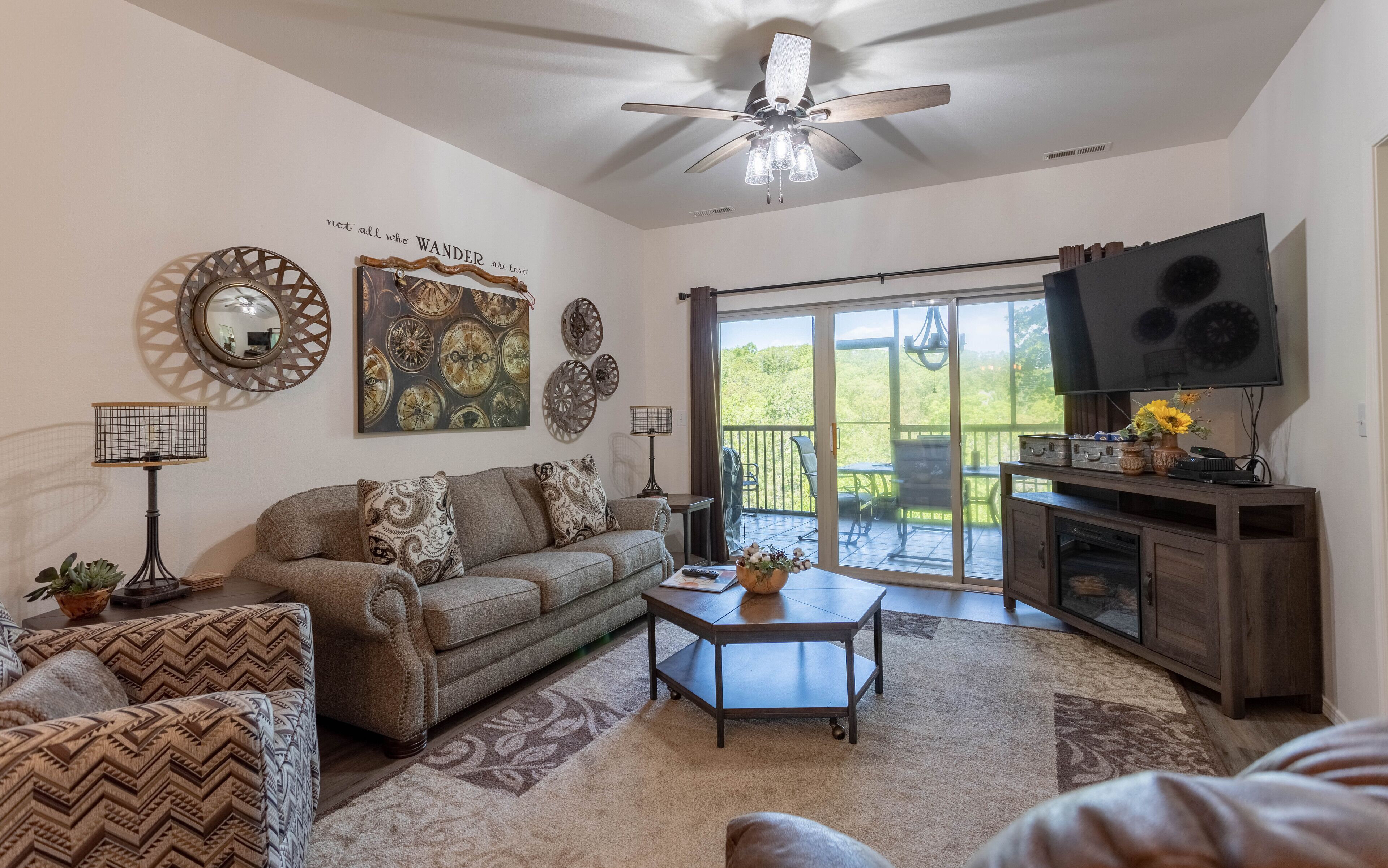 A living room with a ceiling fan, a sofa, a coffee table, and a TV on a stand.