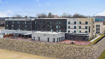 A multi-story building with a stone facade, named 'Courtyard'. It features a rooftop terrace with outdoor seating and a covered area.