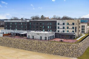 A multi-story building with a stone facade, named 'Courtyard'. It features a rooftop terrace with outdoor seating and a covered area.