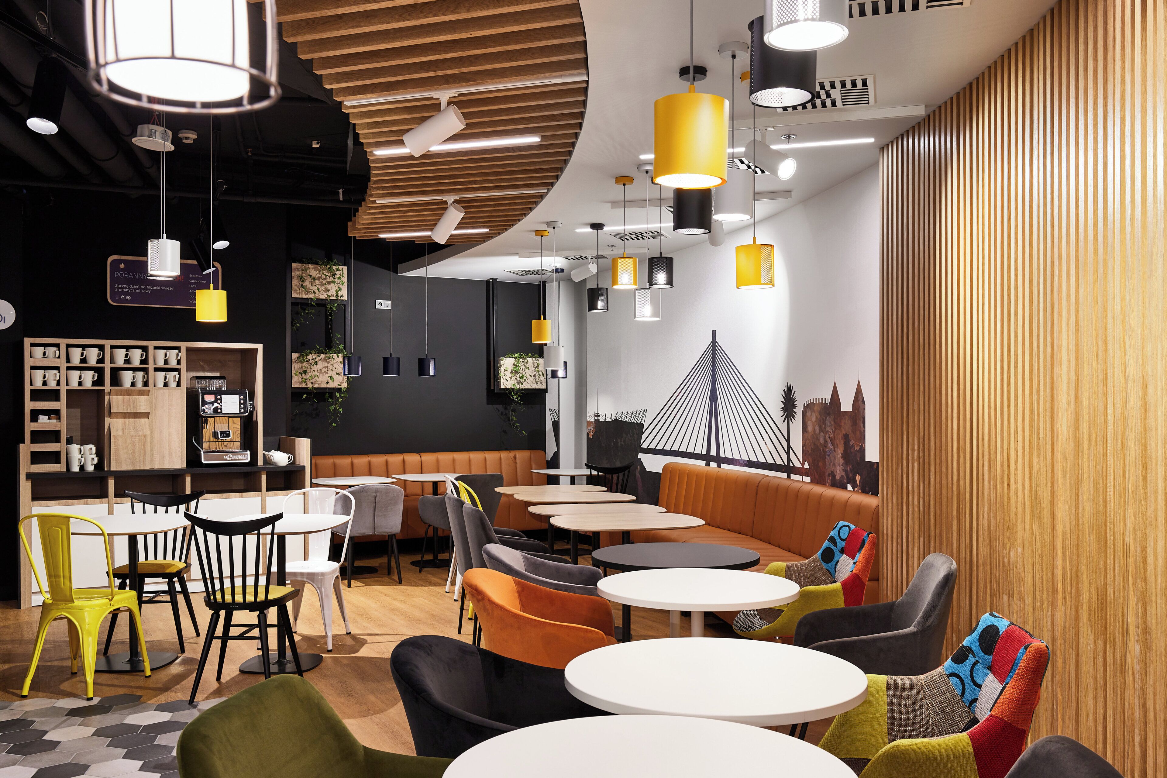 A modern cafe interior with round tables, chairs, and a variety of lighting fixtures.