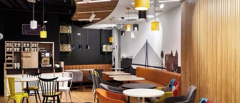 A modern cafe interior with round tables, chairs, and a variety of lighting fixtures.