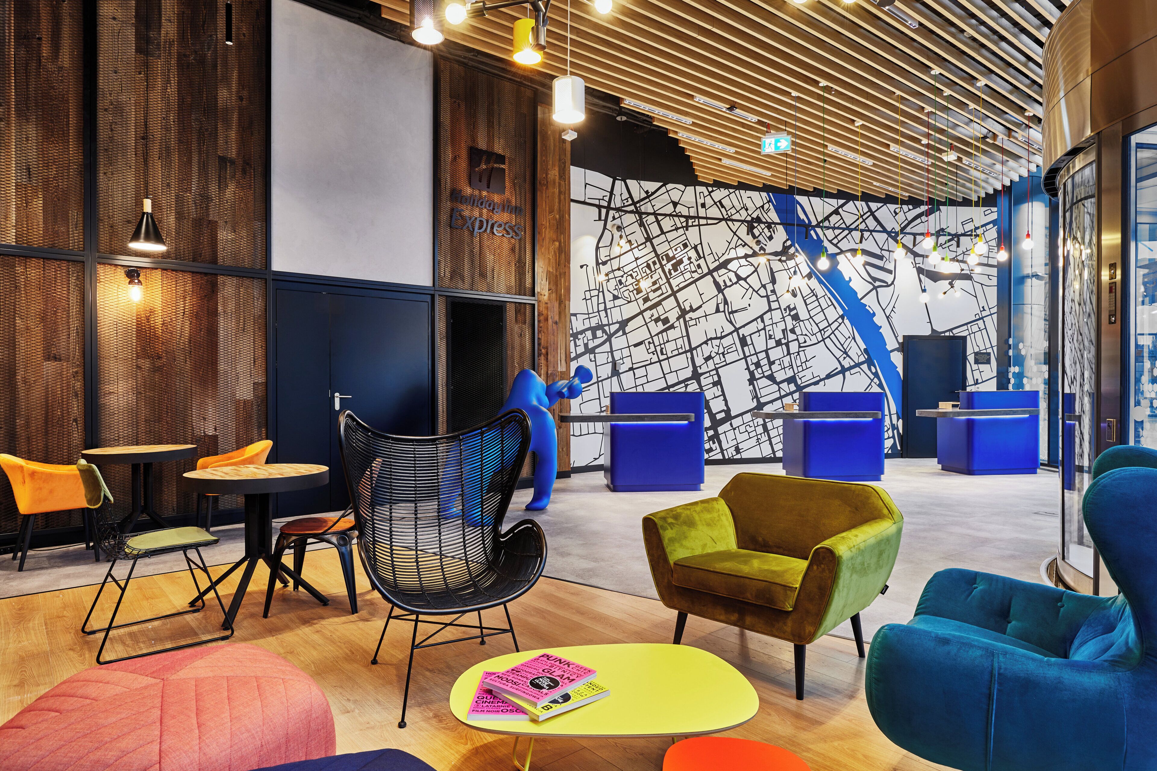 Een modern interieur met een muurschildering van een kaart, zitgedeeltes en een receptiebalie.