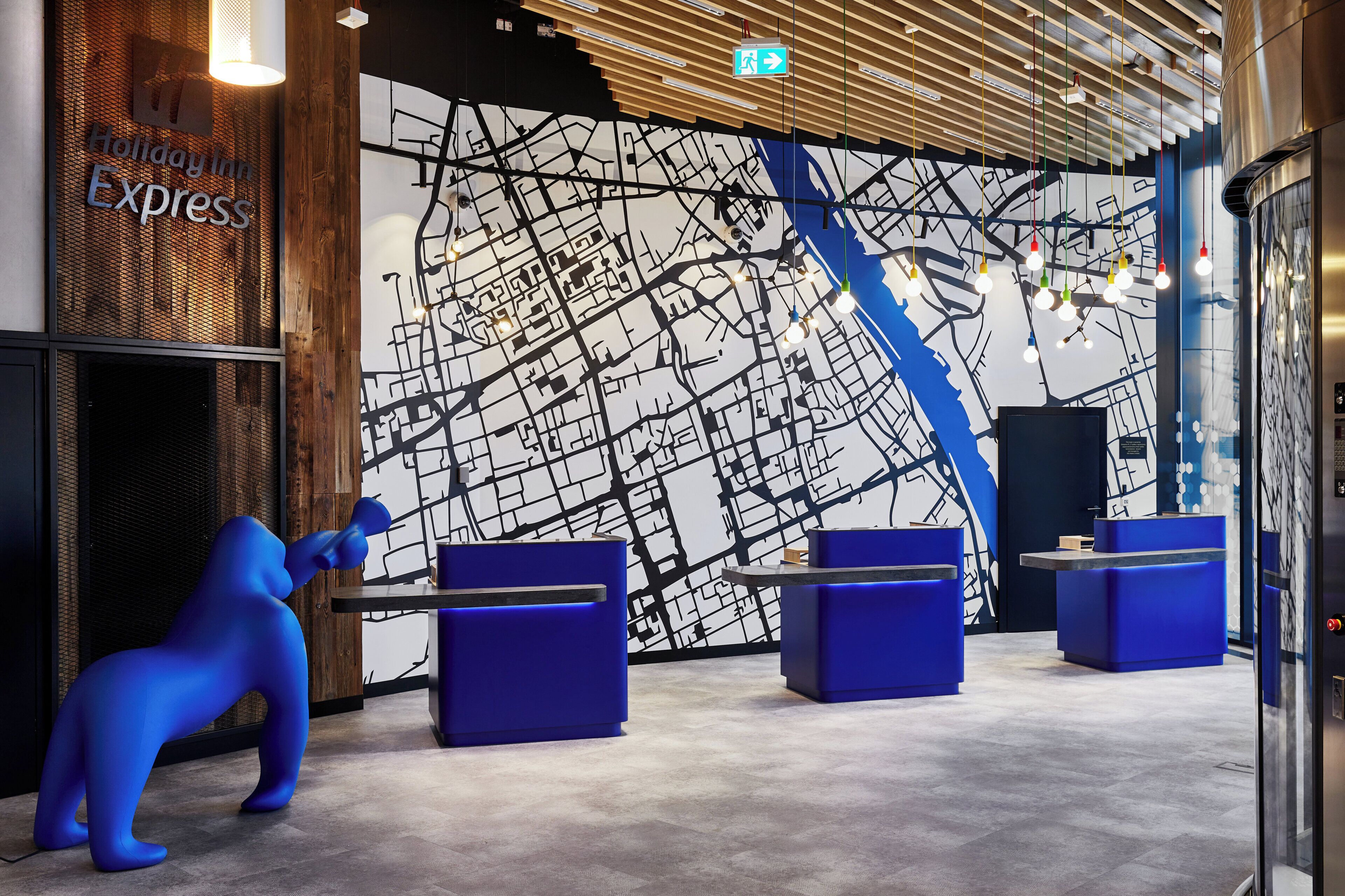A modern reception area with a large map mural, reception desks, and a unique blue sculpture.