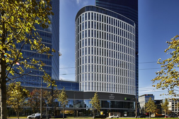 A modern building with a curved facade, large windows, and a sign for Crowne Plaza.