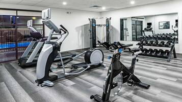 Una palestra con tapis roulant, cyclette e panca per pesi.