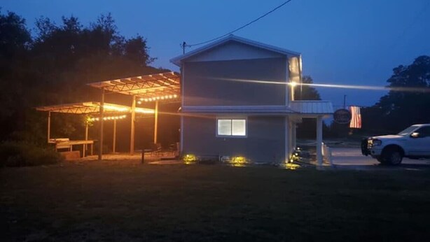 A two-story house with a covered porch and a small front yard. - Lou's Place @ COLE'S LODGE (Carrabelle)