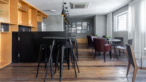 Ein modernes Interieur mit Küchenzeile, Barhocker, Esstischen und Stühlen.