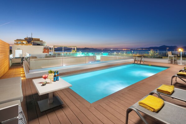 Piscine extérieure, parasols de plage, chaises longues