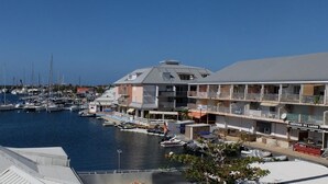 A marina with boats docked, a building with balconies, and a sign reading "CREPERIE DU LAGOM". - Appartement de charme , Marina Royale, Marigot (Marigot)