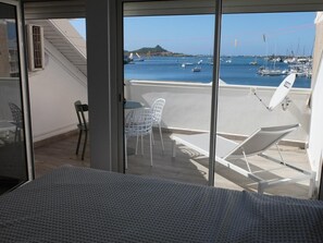 A balcony with a view of a marina, white chairs, a table, and a lounge chair. - Appartement de charme , Marina Royale, Marigot (Marigot)
