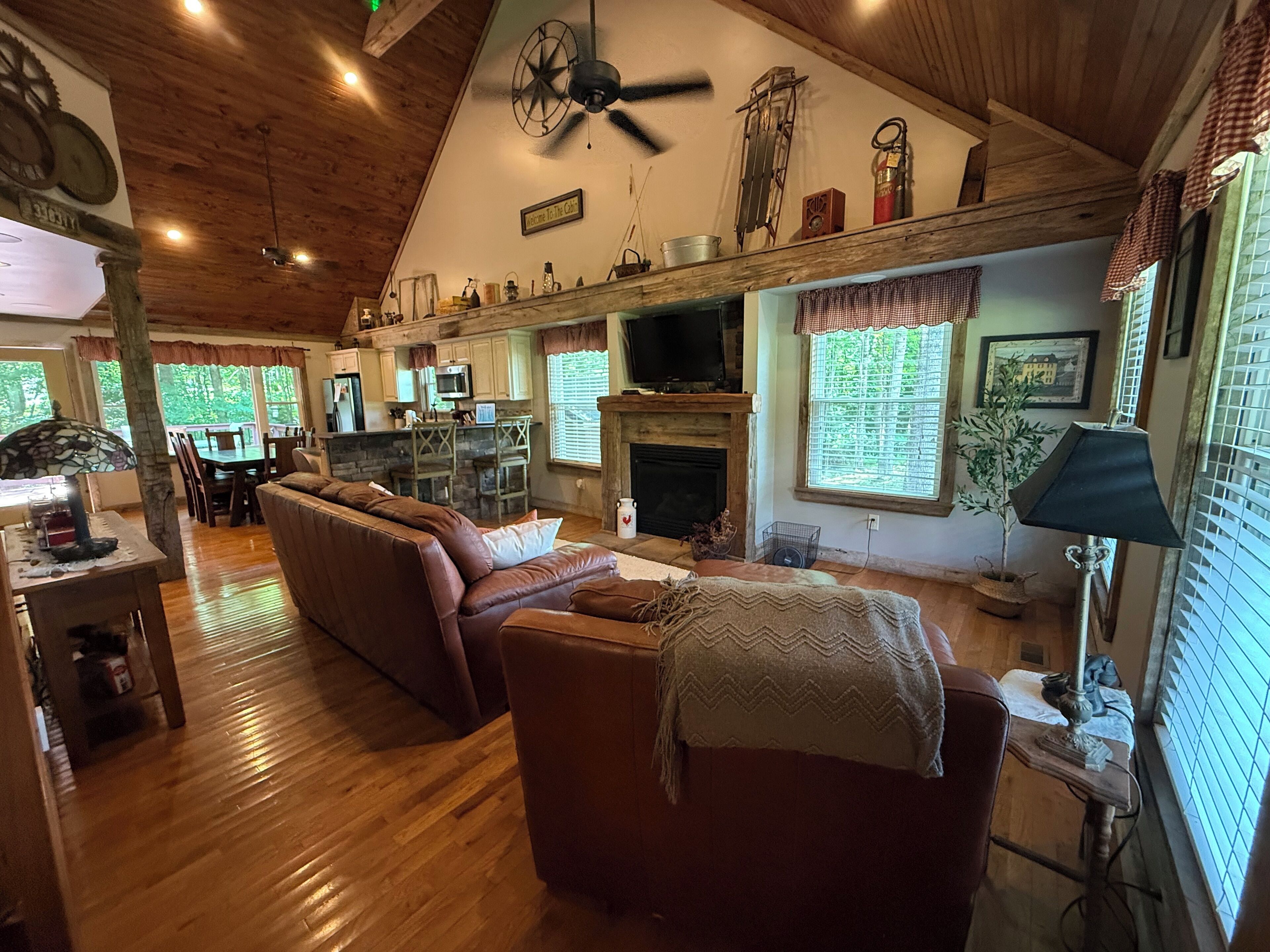 A spacious living room with a fireplace, a dining area, and a kitchen with a large TV.