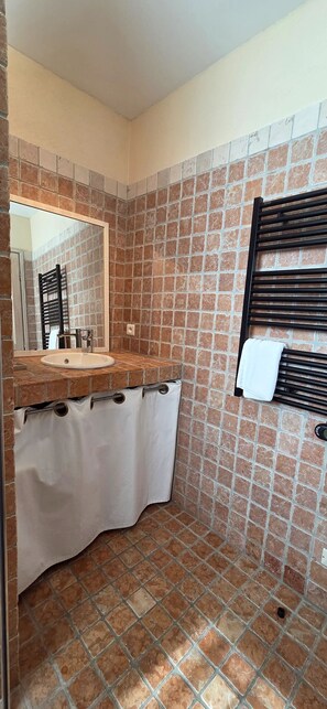A bathroom with a tiled floor, a sink, a mirror, and a towel rack. - Detached cottage for 2 Villa Garlaban Gemenos **** (GEMENOS)
