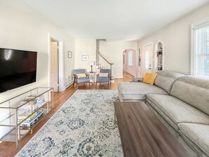 Een smart-tv, een open haard, boeken en een kantoor