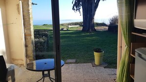 A room with a view of the sea, a small table, a potted plant, and a Sony TV. - T1 with sea view and access 30 meters (Sarzeau)
