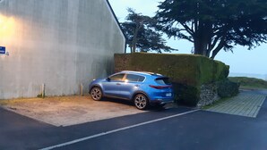A blue car parked in front of a building with a sign that reads "RESIDENCE La Plage de Keristanne." - T1 with sea view and access 30 meters (Sarzeau)