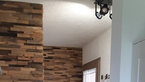 A hallway with a wooden wall, a bench, and a door with a curtain. - T1 with sea view and access 30 meters (Sarzeau)