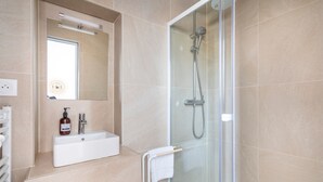A modern bathroom with a glass-enclosed shower, a sink with a mirror, and a towel rack. - JADE - LES COCONS - One Bedroom Apartment, Sleeps 2 (Marseille)