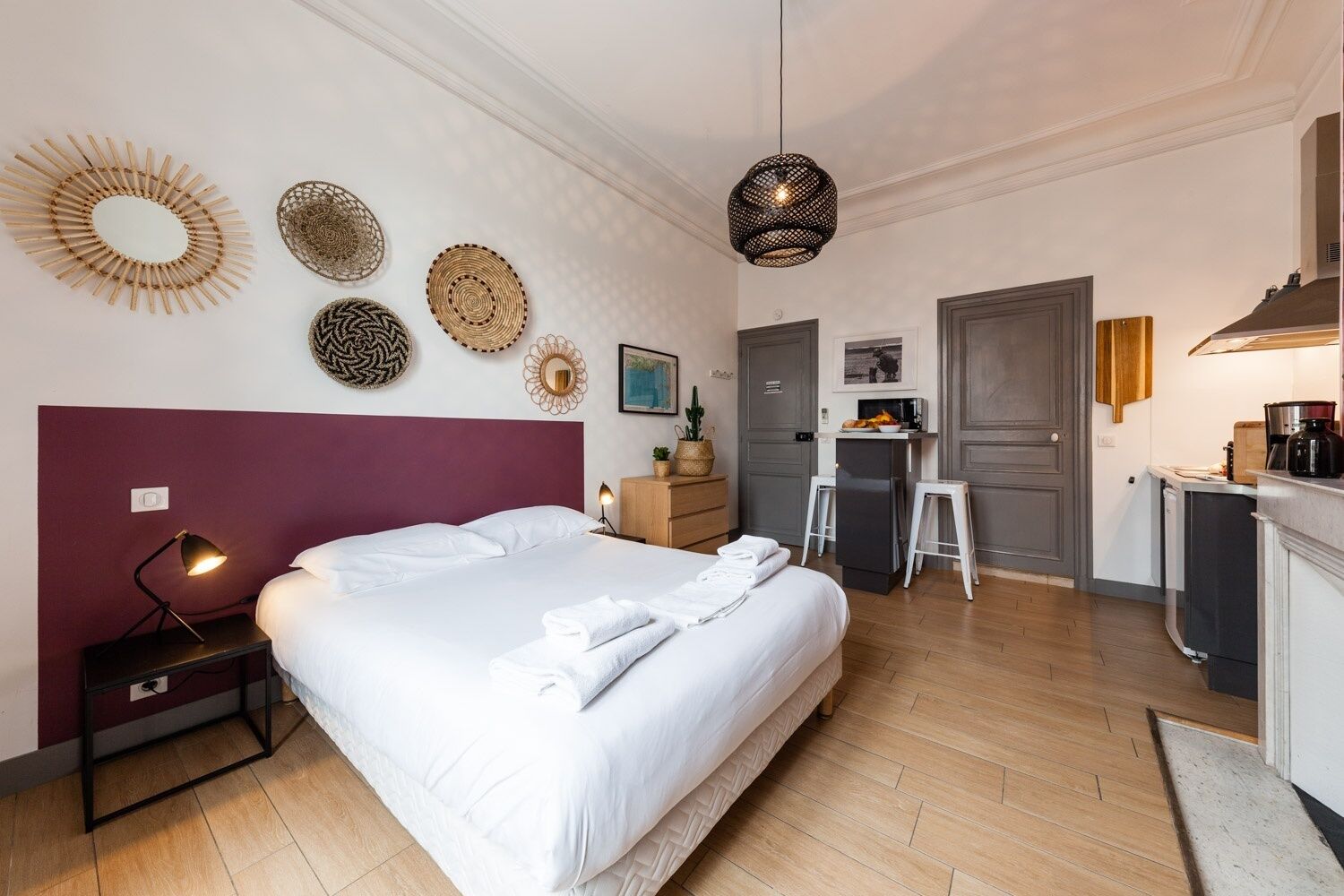 A bedroom with a bed, bedside table, lamp, and decorative wall art.