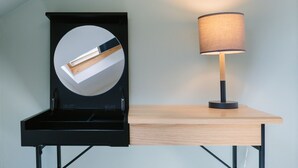 A desk with a lamp and a circular mirror.