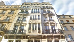 Un edificio de varios pisos con balcones y grandes ventanales.