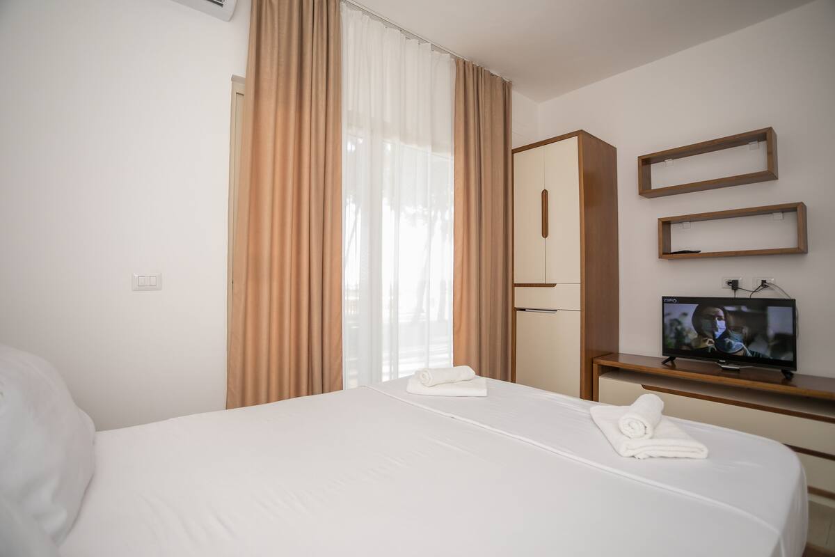 Una habitación de hotel con cama, televisión, armario y escritorio.