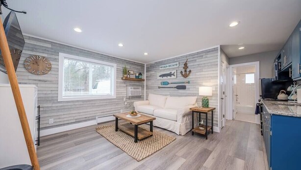 A modern living room with a sofa, coffee table, and decorative wall art. - Lakeside Serenity: One-Bedroom Villa (Bridgman)