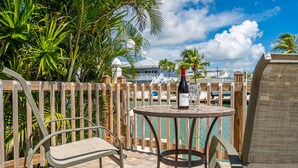 A patio with a round table, two chairs, and a bottle of wine. - WATERFRONT!! Home w/ 37.5-ft dock, Cabana Club Membership!!! (Key Colony Beach)