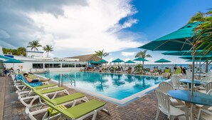 A swimming pool with lounge chairs and umbrellas, surrounded by palm trees and a clear sky. - WATERFRONT!! Home w/ 37.5-ft dock, Cabana Club Membership!!! (Key Colony Beach)
