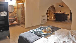 Une chambre confortable avec un lit, une table de chevet, une armoire et une salle de bain équipée d’une douche et d’un lavabo.