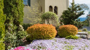 A two-story building with a beige facade, arched windows, and a balcony with a railing. - Luxurious Condominium 1 - 3 bedrooms available (Hood River)