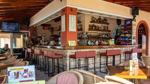 Eine Bar mit Korbstühlen und einer Steintheke.