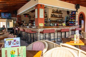 Enjoy a drink at the bar, surrounded by comfortable seating and a lively atmosphere.