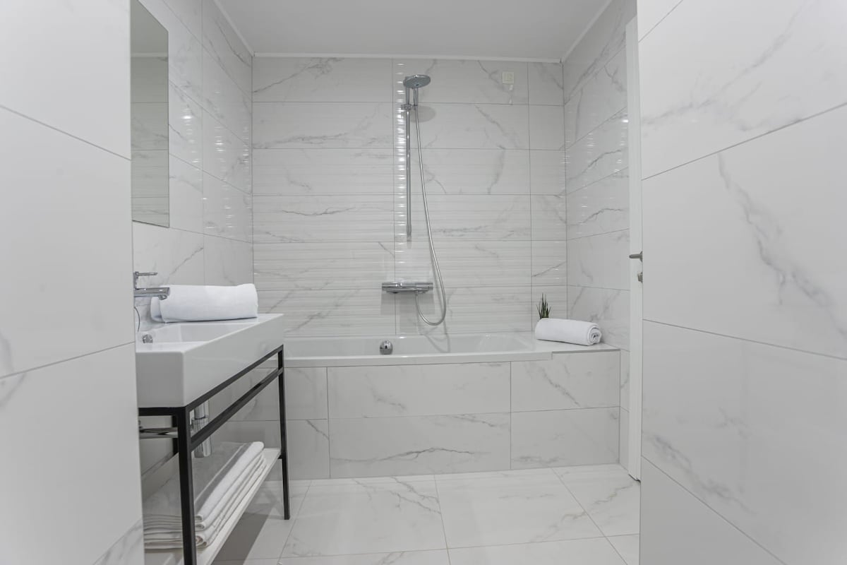 Un baño moderno con ducha, lavamanos e inodoro.