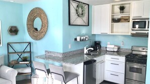 A compact kitchen with white cabinets, a stainless steel dishwasher, and a gas stove. - Beautifully renovated Gulf efficiency!  (North Redington Beach)
