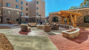 A courtyard with outdoor seating, a basketball court, and a pergola. - Great for Business Travelers! Comfortable Suite in St. Louis | BBQ Area (Maryland Heights)