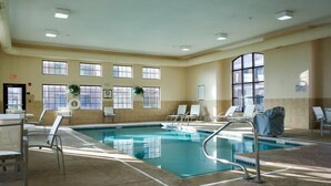 An indoor swimming pool with clear water, surrounded by lounge chairs and a tiled floor. - Relaxing Retreat Near Cleveland | Shared Indoor Pool + BBQ Area (Stow)
