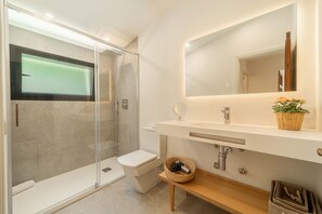 A modern bathroom with a glass-enclosed shower, a white toilet, a wooden vanity, and a mirror above the sink. - Villa CIUTADA 3 bedroom , with swimming pool and barbecue Pollensa (Pollensa)
