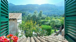 A terrace with a view of a lush valley and mountains.