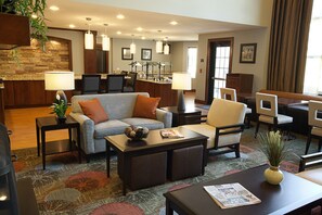 Relax in our inviting lobby with comfortable seating, a kitchen area, and a large mirror.