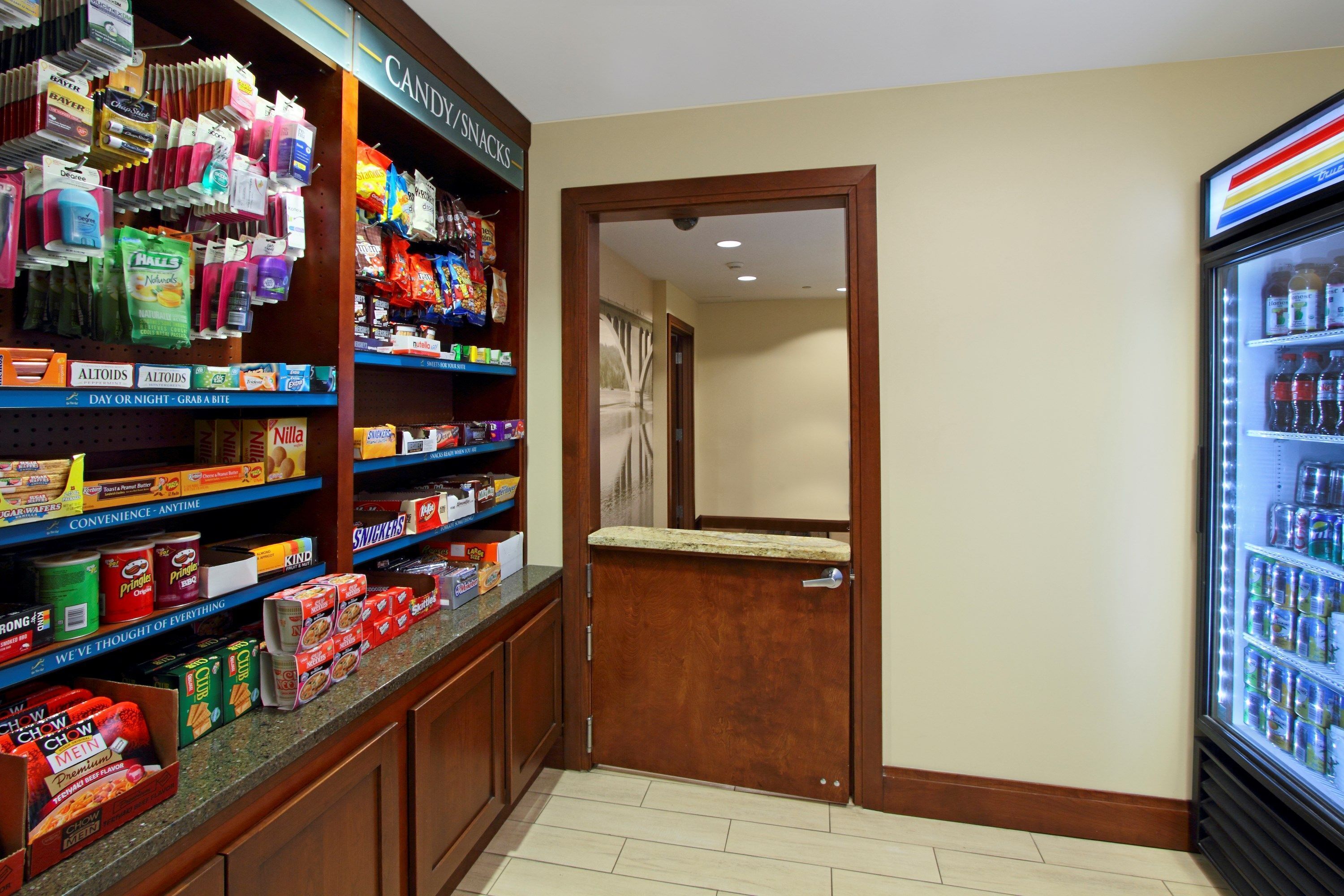 Una tienda de conveniencia con bocadillos y una amplia selección de productos envasados, incluyendo alimentos refrigerados.
