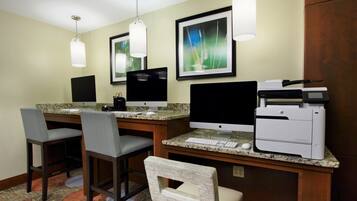 A hotel workspace with two desks, computers, and a printer.
