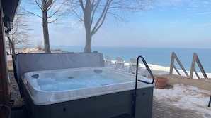 Un bain à remous équipé d’une échelle, de marches et offrant une vue sur l’océan.