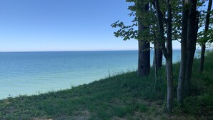 Un paysage naturel offrant une vue dégagée sur la mer, les arbres et les prairies.