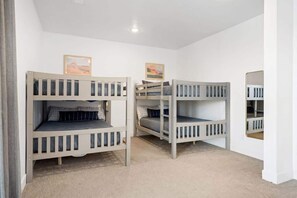 A room with bunk beds, a carpeted floor, and a ceiling light. - The Lofts #33 | Townhome Pool Resort | Poolside (Saint George)