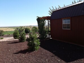 Situated in a rural setting, this charming building features a single window and a sloped metal roof.