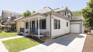 Una casa a un piano con veranda coperta, garage e prato curato.