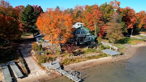 A lakeside cabin with a dock, surrounded by autumn foliage. - River Cabin at Sweet Retreat  Waterfront Escape (Sault Ste. Marie)